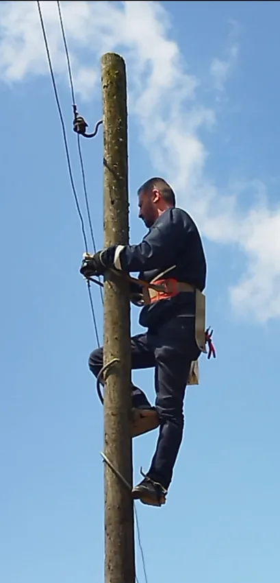 Elektrik direği üzerinde çalışma yapan elektrikçi